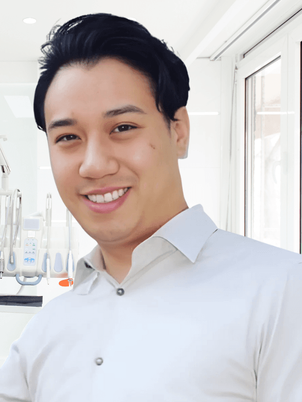 Professional headshot of Dr. Russell Chong smiling in a dental office setting.